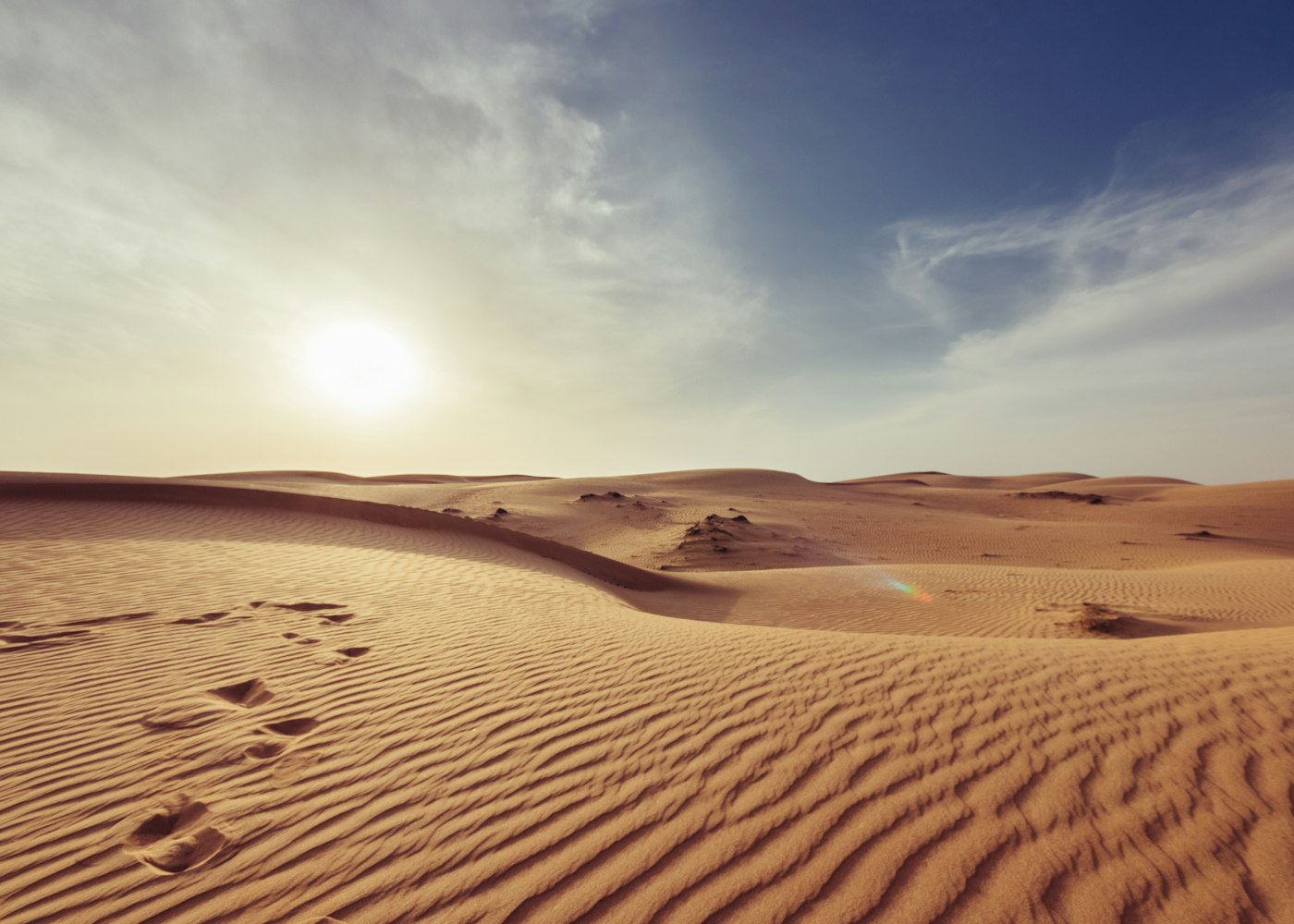 Caravan crossing dunes at golden hour